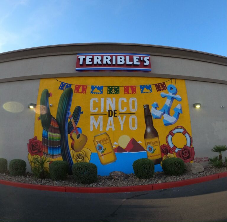 A terrible art mural of pacifico bottles that says cinco de mayo