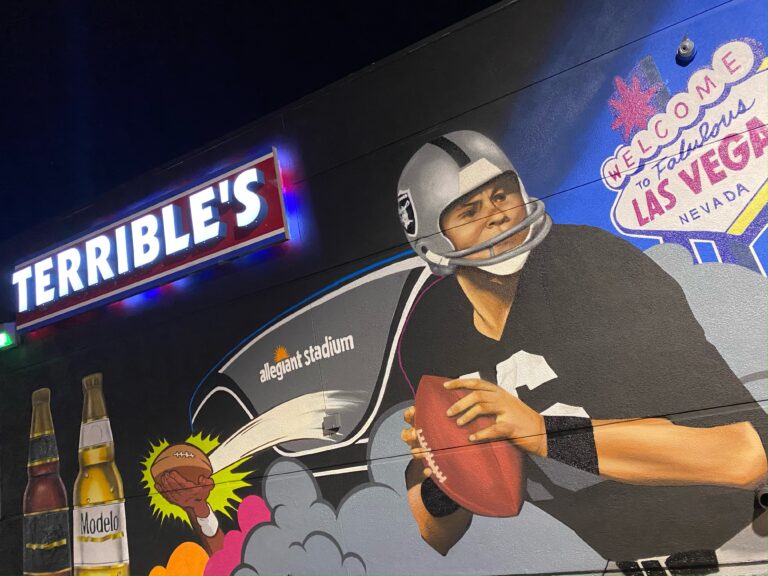 A terrible art mural of a football player in front of allegiant stadium with modelo bottles